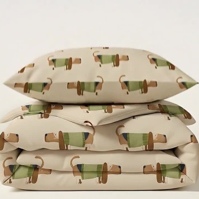 Manta dobrada com padrão de cães e almofadas empilhadas