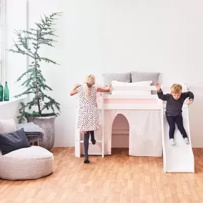 Cama infantil branca de madeira com escada e escorrega numa divisão clara com chão de madeira