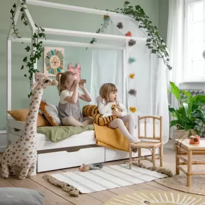 Quarto infantil decorado com cama casinha, brinquedos, pelúcia, móveis de madeira clara e plantas