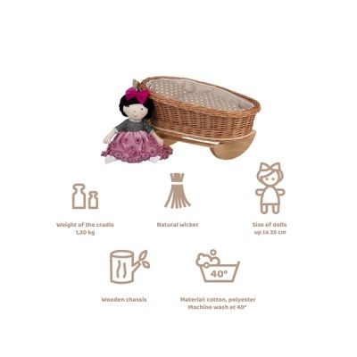 Berço de vime com boneca de pano vestida de rosa, chassis de madeira e ícones informativos