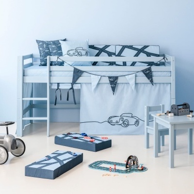 Quarto infantil com móveis e decoração em tons de azul claro e brinquedos relacionados a carros