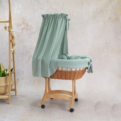 Berço de bebé em vime com tecido verde água e estrutura de madeira com rodas