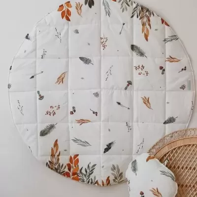 Tapete redondo acolchoado com padrão de folhas e penas em tons de castanho e cinza