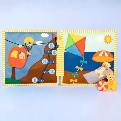 Livro de pano infantil com cenas coloridas e texturas diferentes