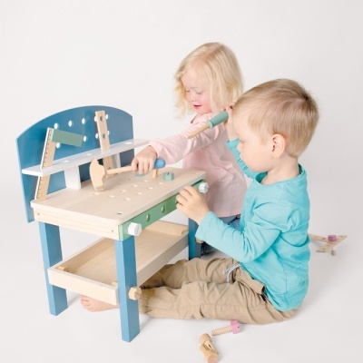Mesa de trabalho infantil em madeira com suporte azul e bancada clara com crianças a brincar