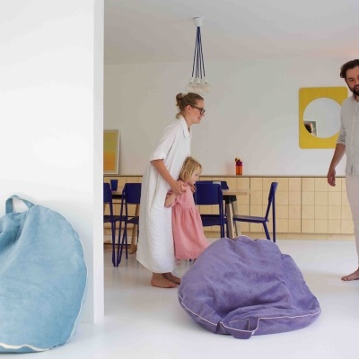 Sala com dois pufes azuis claros e escuros e família com duas crianças e dois adultos