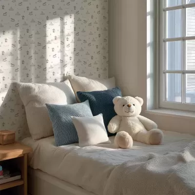 Cama com almofadas e ursinho de pelúcia junto a uma janela e papel de parede infantil.