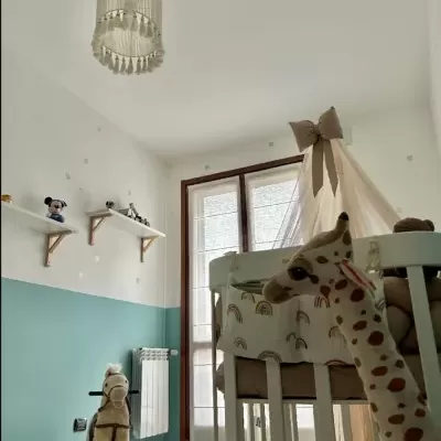 Quarto infantil com cama branca, dossel bege, brinquedos de peluche, prateleiras e janela grande