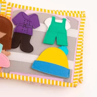 Livro de tecido com roupas de criança em feltro de várias cores