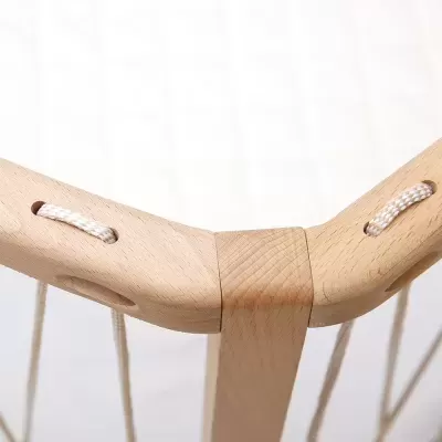 Estrutura em madeira clara com cordas brancas e padrão em cruz