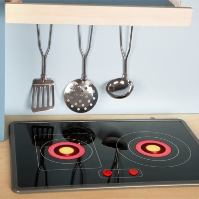 Placa de fogão elétrica preta com queimadores circulares e utensílios metálicos pendurados