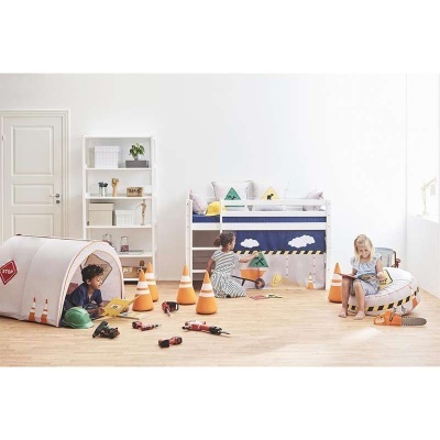 Quarto infantil com cama alta, tenda branca, cones de trânsito e três crianças a brincar