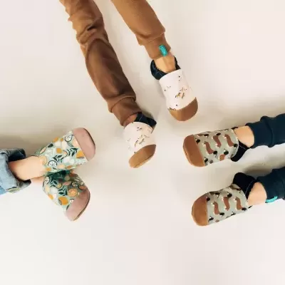 Três pares de sapatilhas coloridas para criança com estampados variados sobre fundo branco.