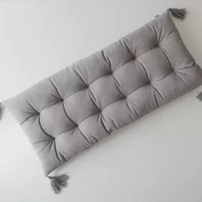 Almofada cinzenta retangular com tasséis nos cantos
