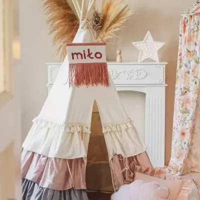 Tenda tipi infantil em tecido com decoração e almofadas rosas em ambiente interior acolhedor