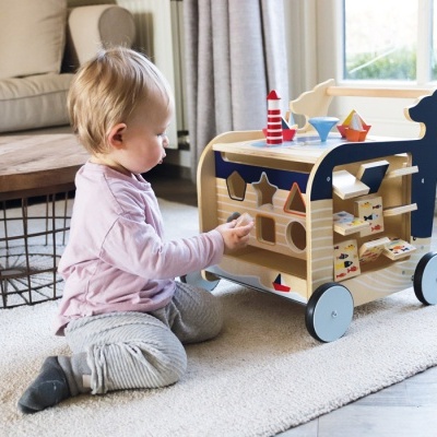 Menino brinca com brinquedo de madeira colorido com formas geométricas