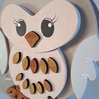 Figura decorativa de coruja em madeira com detalhes castanhos e corações esculpidos