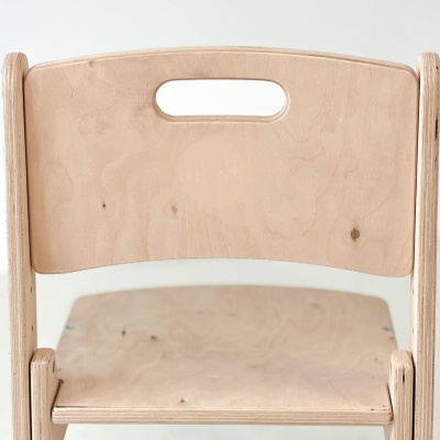 Cadeira infantil em madeira clara com abertura no encosto e texto gravado little haven