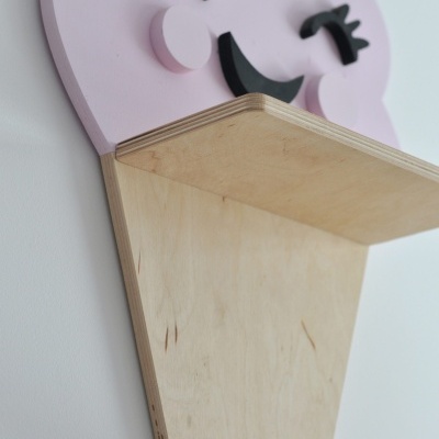 Prateleira de madeira clara com suporte decorativo de nuvem cor-de-rosa sorridente