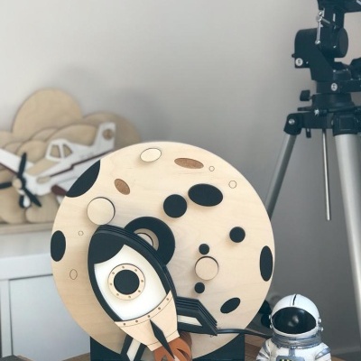 Brinquedo decorativo de madeira com tema espacial, foguetão e astronauta.
