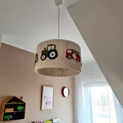 Lustre de teto infantil com cúpula bege decorada com veículos coloridos numa sala clara