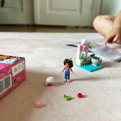 Brinquedo com figura humana e animal sobre superfícies rosa