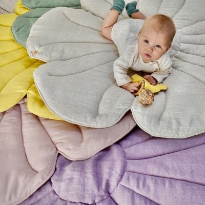 Tapetes florais coloridos acolchoados para bebés sobre chão de madeira