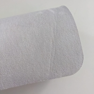 Rolo de tecido branco com textura suave sobre superfície branca