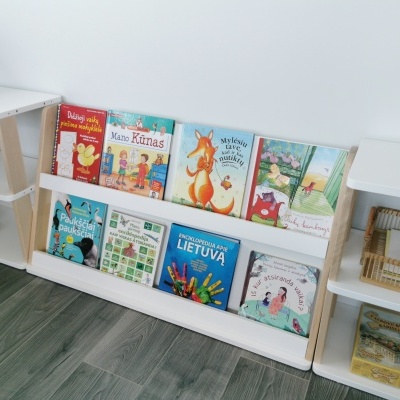 Estante branca com livros infantis coloridos e brinquedos organizados