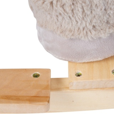 Base de madeira clara com peças quadradas fixadas por parafusos dourados e objeto felpudo branco
