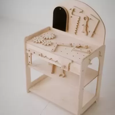 Bancada de trabalho infantil em madeira clara com ferramentas decorativas