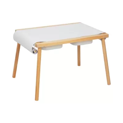 Mesa de madeira clara com papel branco no tampo e duas gavetas