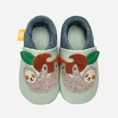 Sapatos de criança verdes com aplicação de preguiça e folhas