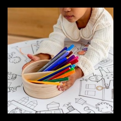 Copo de madeira com canetas coloridas em cima de desenho para colorir