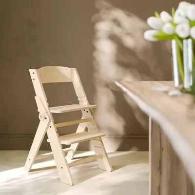 Cadeira infantil em madeira clara com assento ajustável num ambiente interior