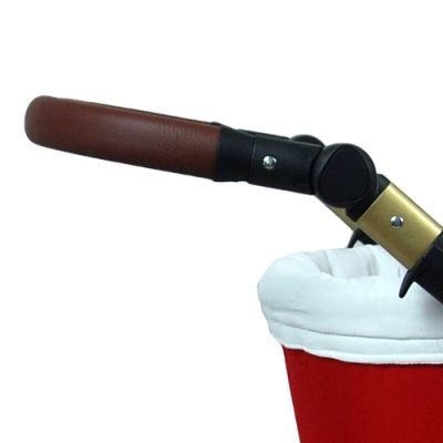 Pega de carrinho de bebé em couro castanho com estrutura preta e dourada e tecido vermelho com almofada branca.