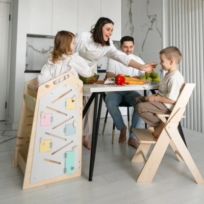 Mesa branca com pernas pretas e cadeiras de madeira clara numa cozinha moderna