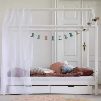 Cama infantil branca em madeira com cortina branca e decoração colorida