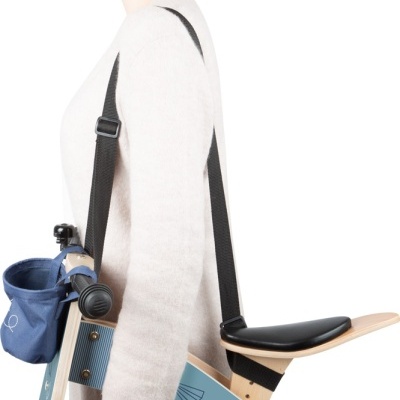 Homem de lado com suporte de madeira e assento preto suspenso por alças pretas