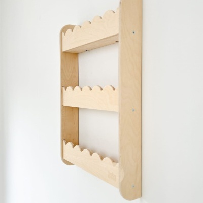 Prateleira de parede em madeira clara com três níveis e bordas onduladas