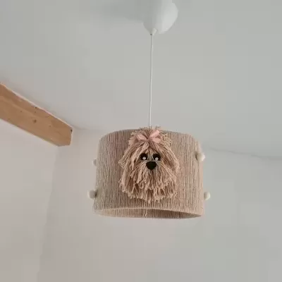 Luminária pendente com cúpula de tecido bege decorada com figura de cão de fio felpudo