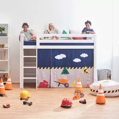 Cama alta infantil branca com cortina temática de construção e brinquedos no chão