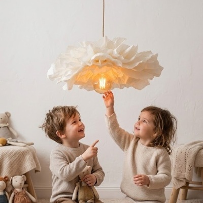 Lâmpada pendente com cúpula branca em forma de flor e luz amarela num quarto infantil com crianças a brincar