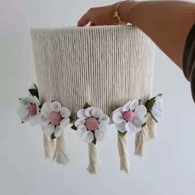 Abajur branco decorado com flores de tecido e franjas pendurado