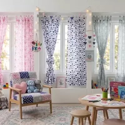 Quarto infantil com cortinas coloridas e móveis de madeira em ambiente iluminado