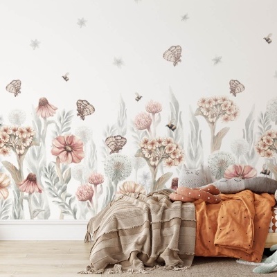Quarto infantil com vinil de flores e borboletas, cama com roupa laranja e almofadas cinza e rosa