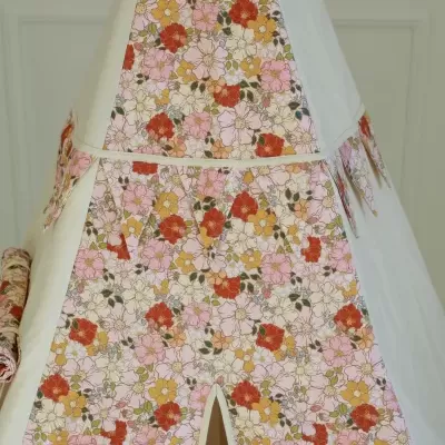 Tenda de criança branca com painéis florais coloridos e franjas decorativas.