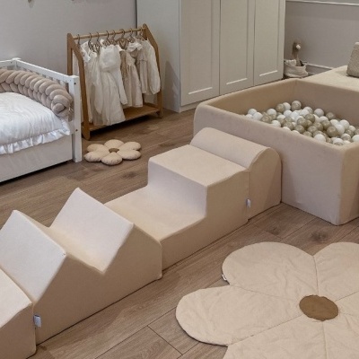 Quarto infantil com cama branca, brinquedos de pelúcia e piscina de bolas neutra