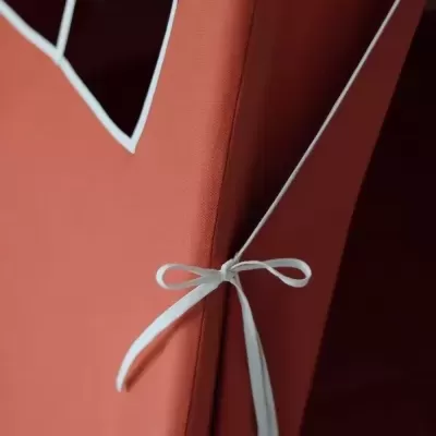 Detalhe de tenda terracota com janela quadrada e corda branca amarrada