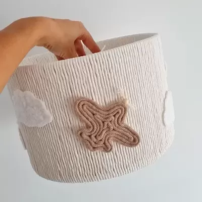 Cesto branco com aplicações de estrela e nuvens em feltro